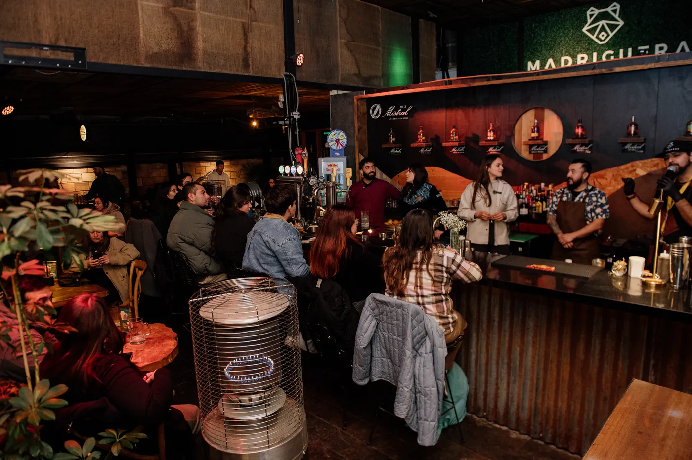 Ambiente de un evento con barra de coctelería llena de invitados en Concepción